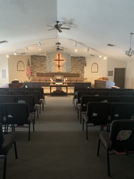 Faith Baptist Church sanctuary viewed down the center aisle toward the cross and altar.